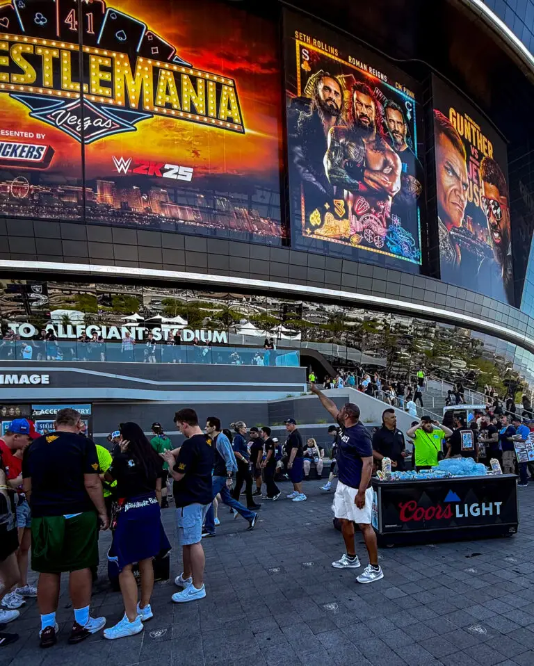 Crowds gathering outside Allegiant Stadium in Las Vegas with giant WrestleMania 41 banners featuring WWE superstars.